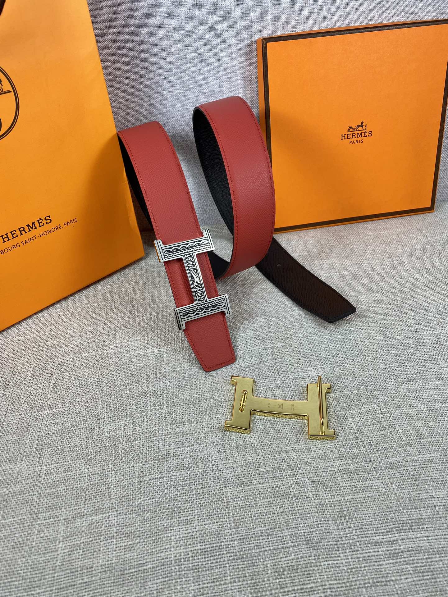 Red and black belt with silver H buckle and gold H buckle piece