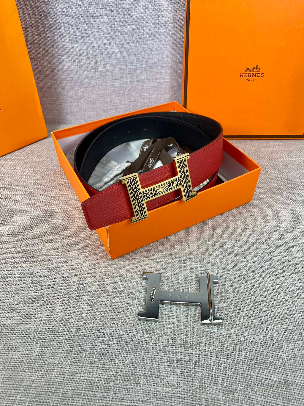 Red and black belt in box with silver engraved H buckle and clasp pieces