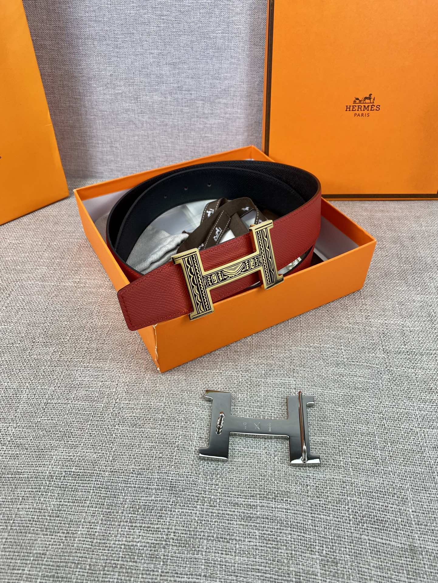 Red and black belt in box with silver engraved H buckle and clasp pieces