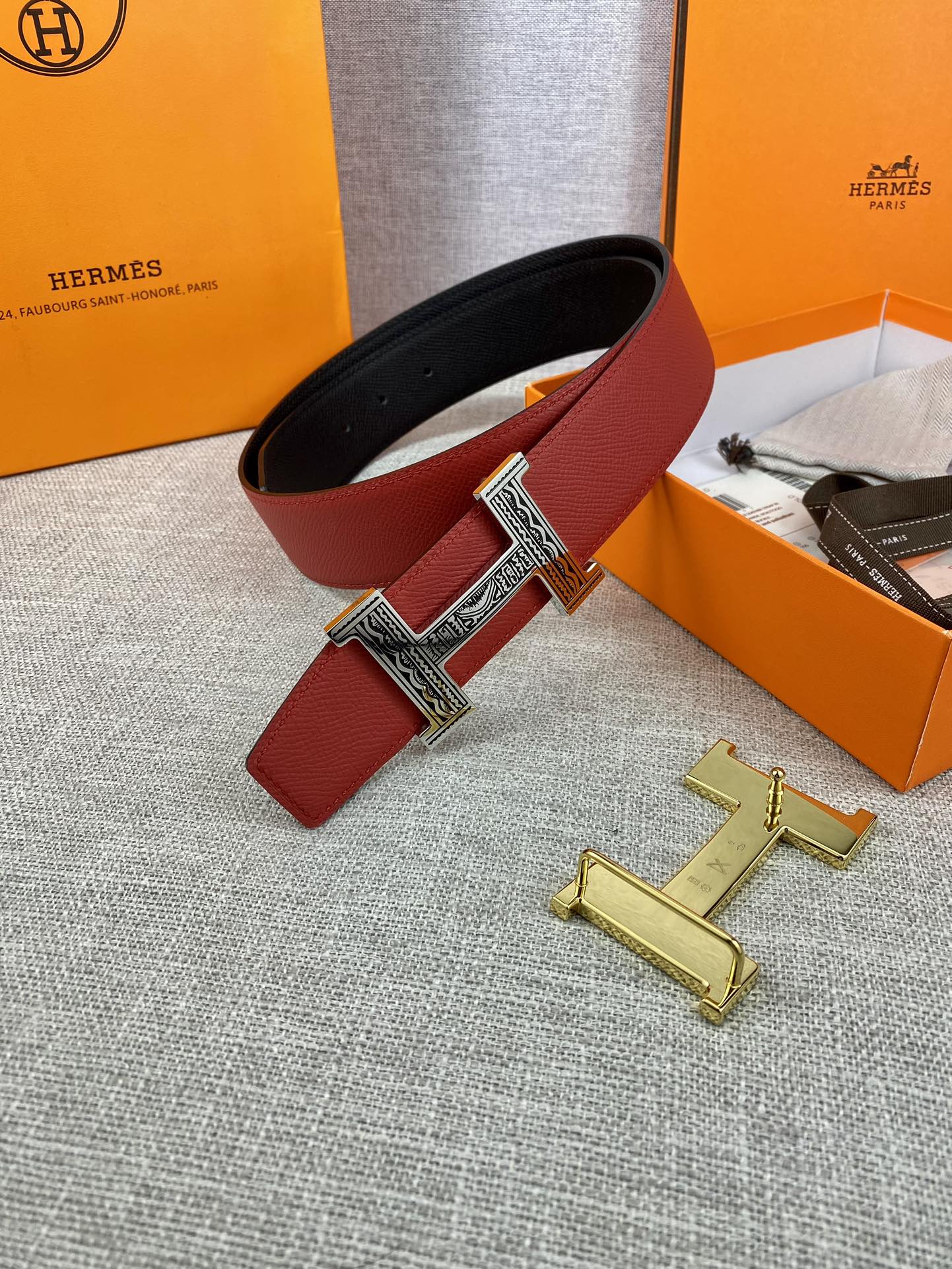 Red and black belt with silver H buckle; shown with gold and silver hardware