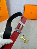 Red and black belt with silver H buckle and gold buckle piece on display