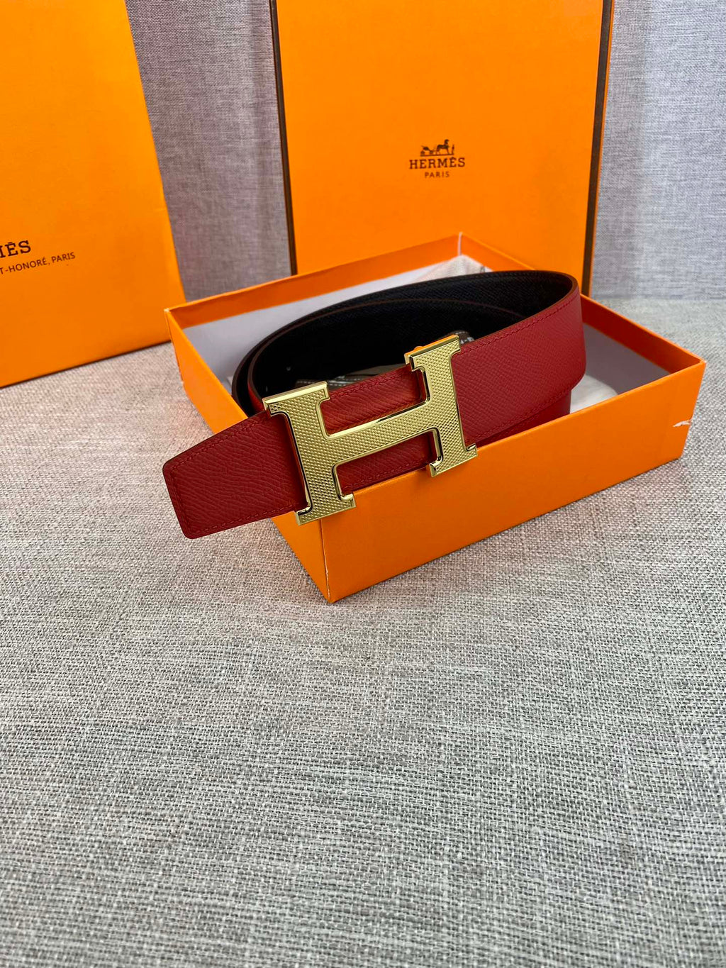 Red leather belt with gold H buckle in orange gift box