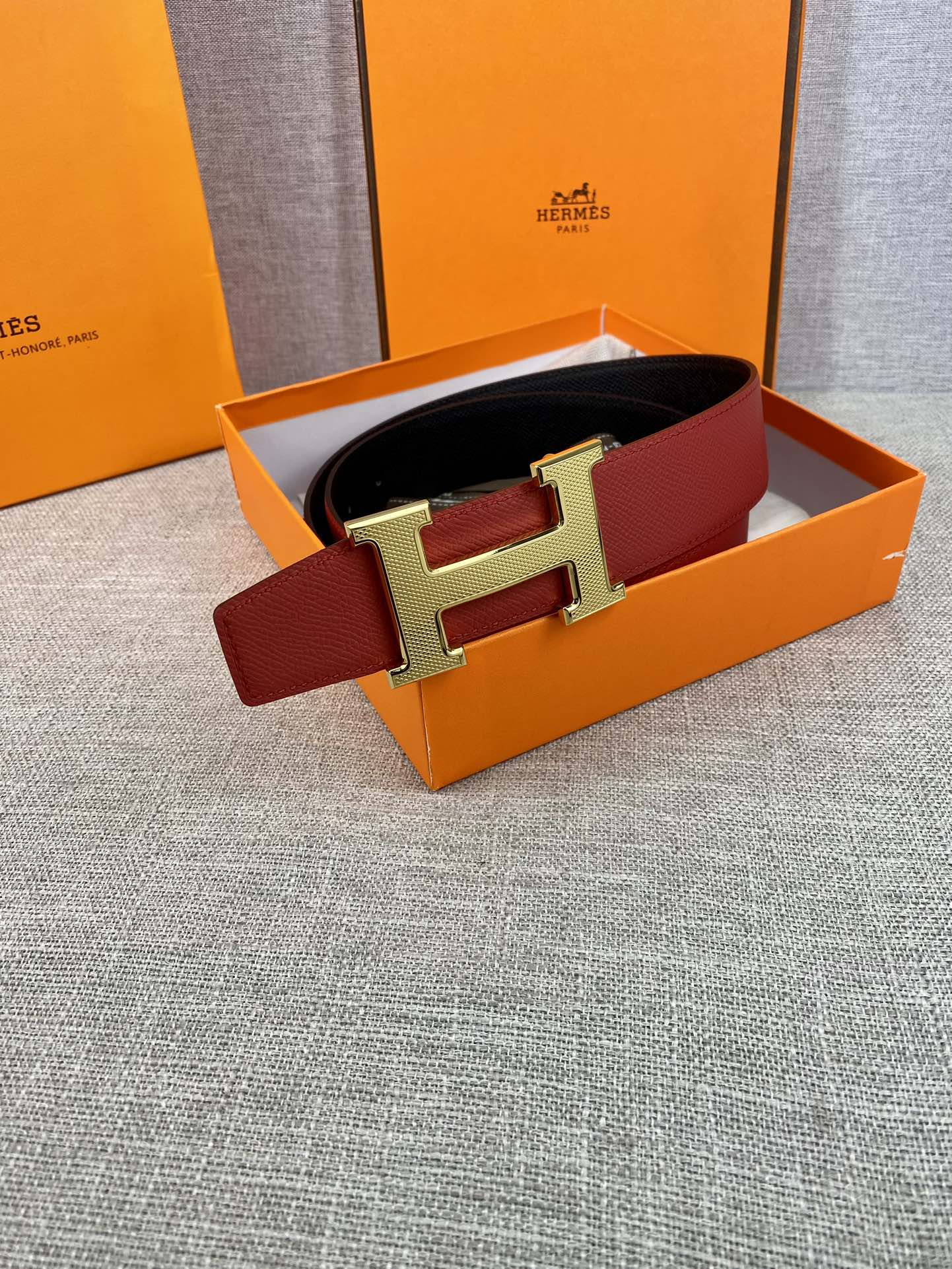 Red leather belt with gold H buckle in orange gift box