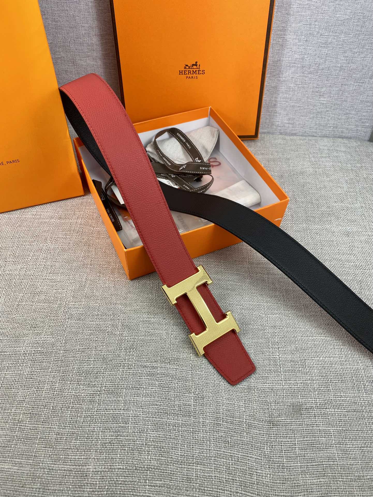 Red leather belt with gold H buckle and black end strap