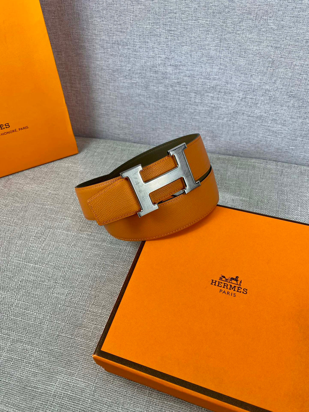 Orange leather belt with silver H buckle and olive keeper strap
