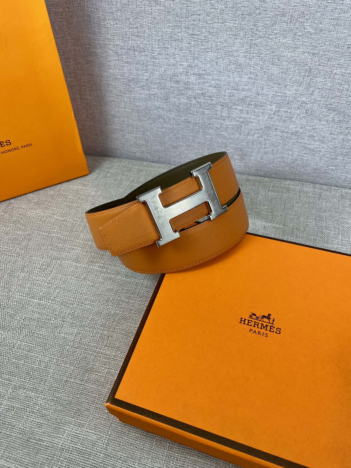 Orange leather belt with silver H buckle and olive keeper strap