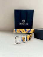 Versace belt with ornate blue-and-yellow print strap and large silver-tone buckle.