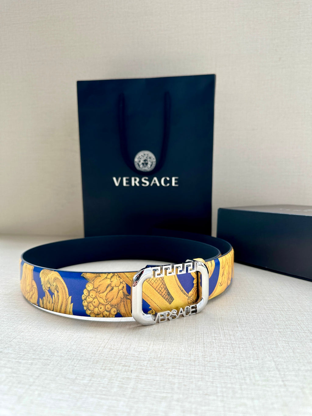 Versace belt on display: blue and gold baroque print strap with silver-tone buckle.