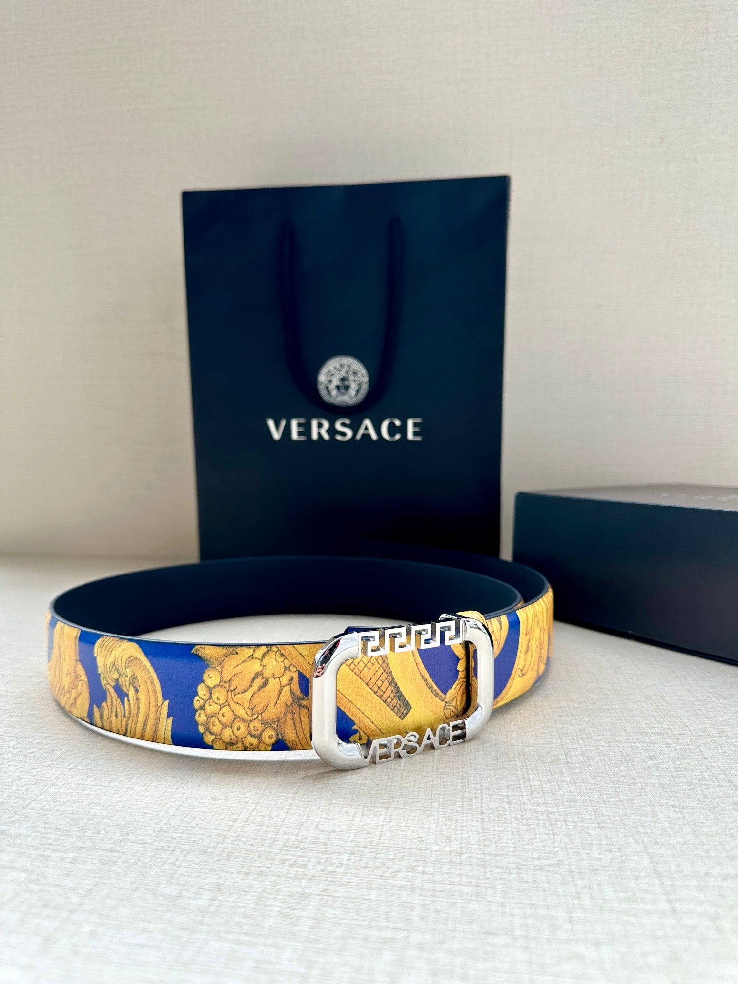 Versace belt on display: blue and gold baroque print strap with silver-tone buckle.