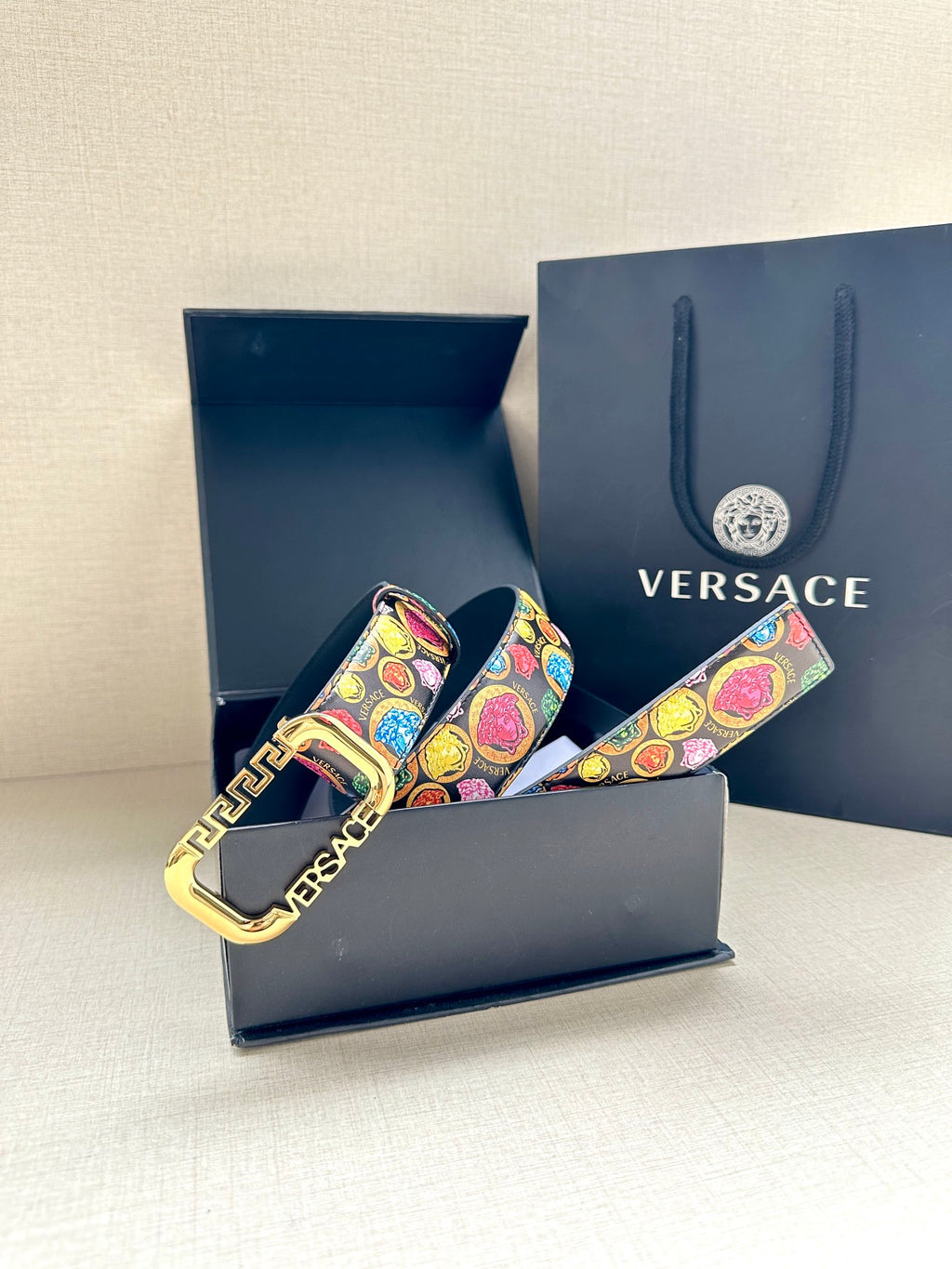 Versace belt in gift box, showing multicolor printed strap and gold-tone buckle