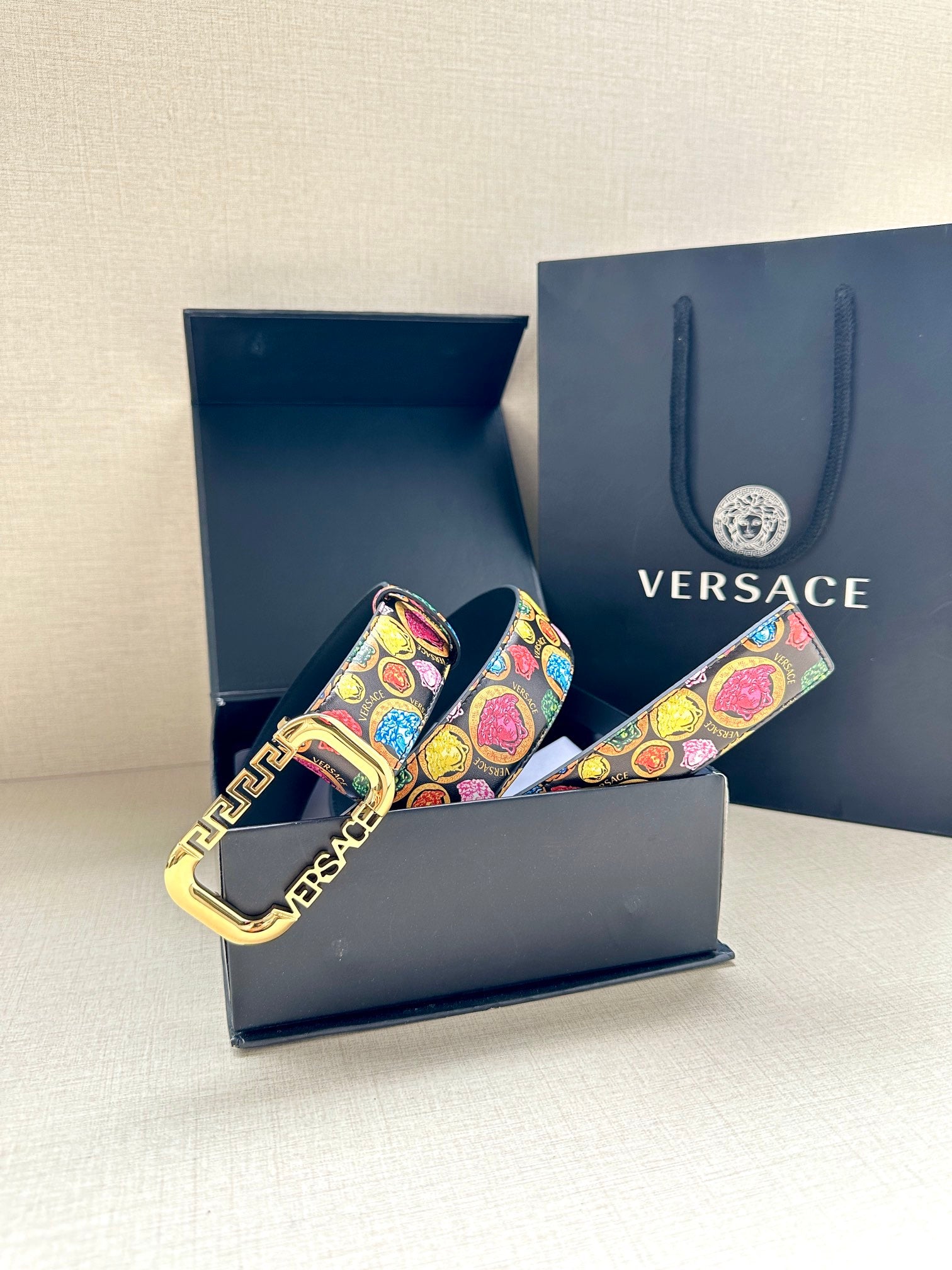 Versace belt in gift box, showing multicolor printed strap and gold-tone buckle