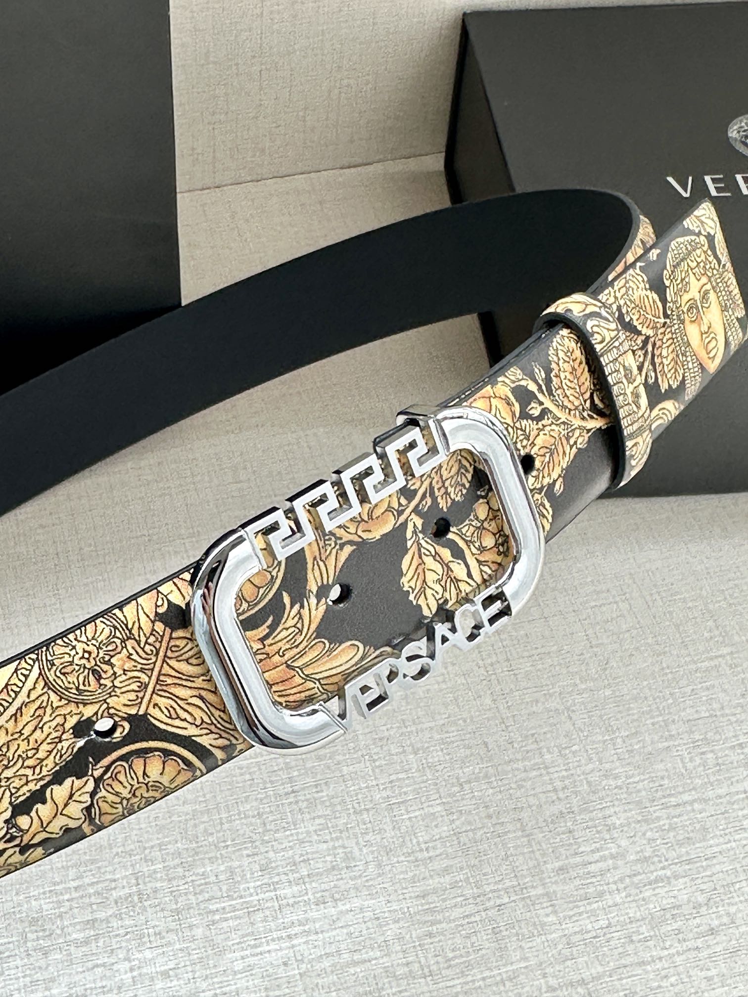 Versace belt close-up with gold baroque pattern and silver buckle
