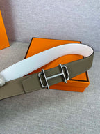 Hermes belt with white leather strap and gold-tone buckle over olive backing