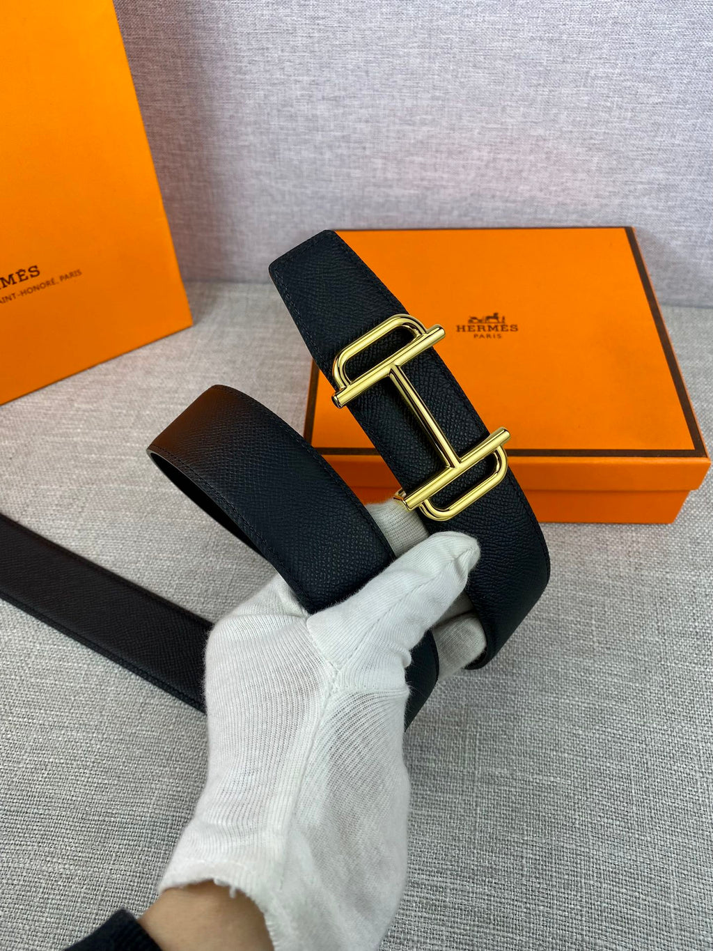 Hermes belt with dark textured leather strap and gold-tone double-prong buckle
