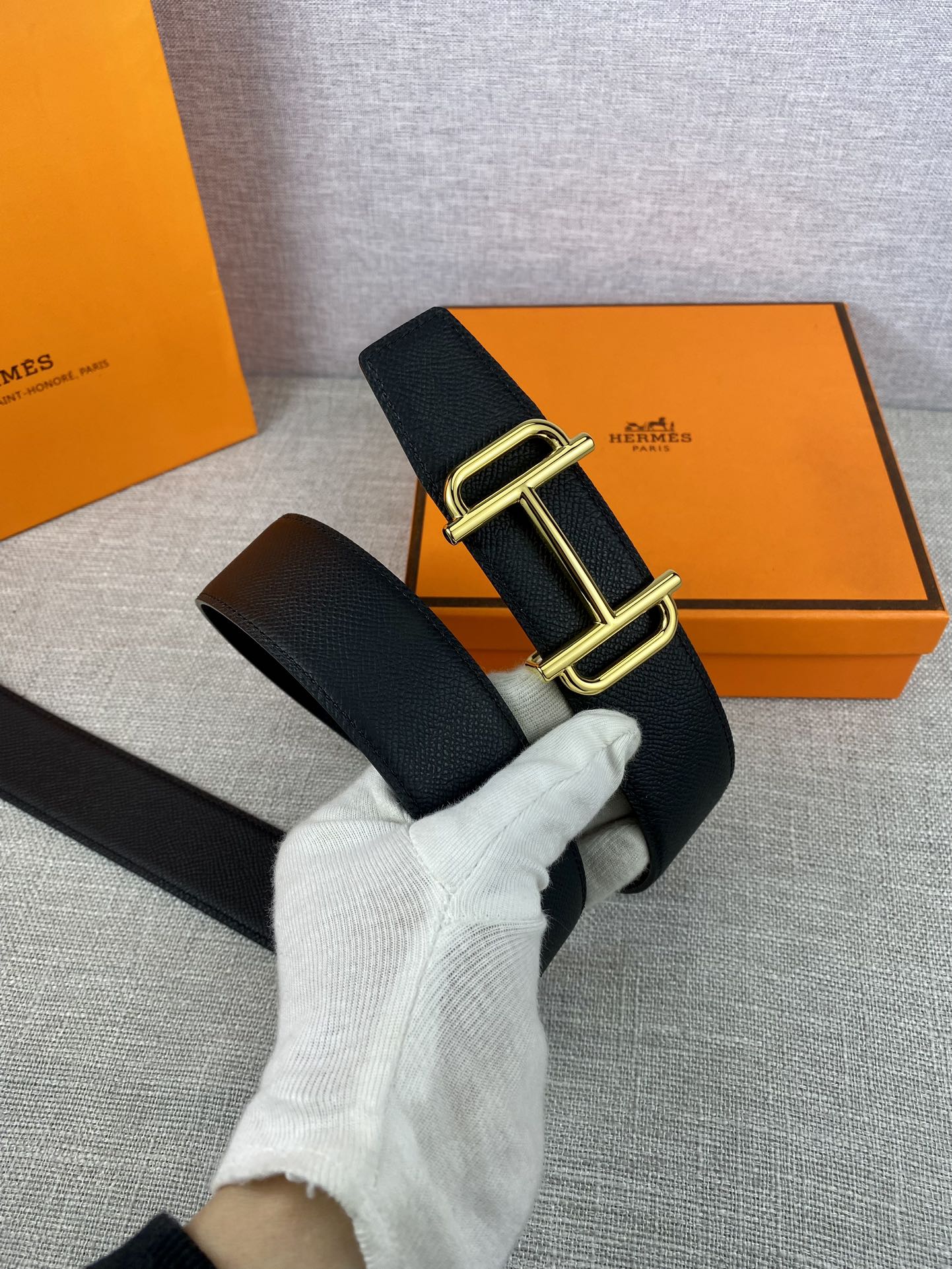 Hermes belt with dark textured leather strap and gold-tone double-prong buckle