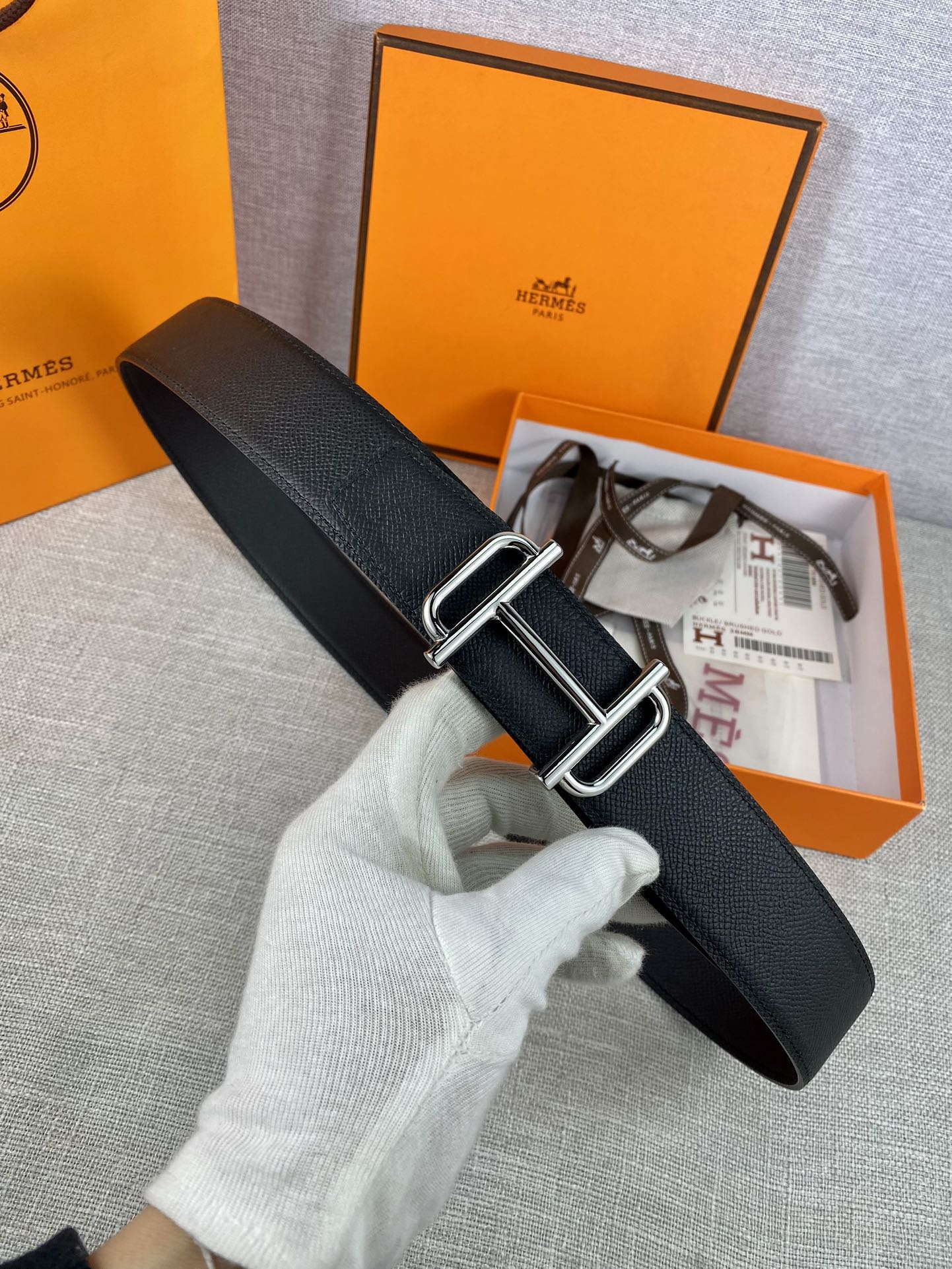 Hermes belt with dark textured leather and silver double-prong buckle, adjustable holes