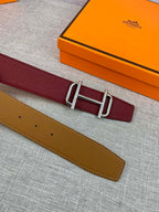 Burgundy leather belt with metallic rectangular buckle and visible strap hole row