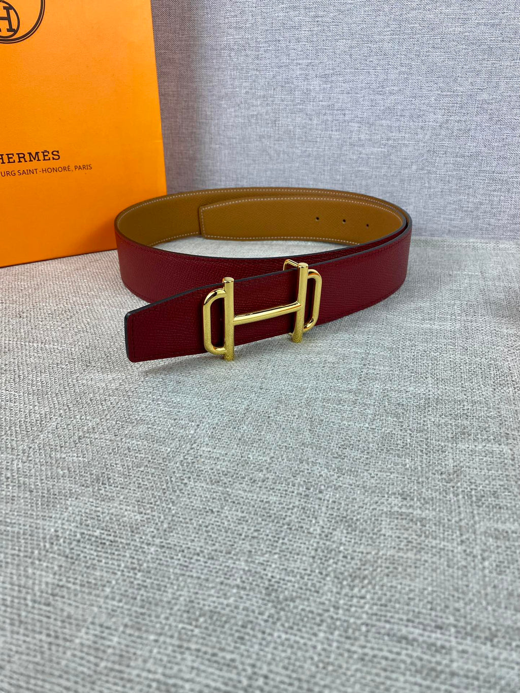 Burgundy leather belt with gold-tone buckle and keeper loop