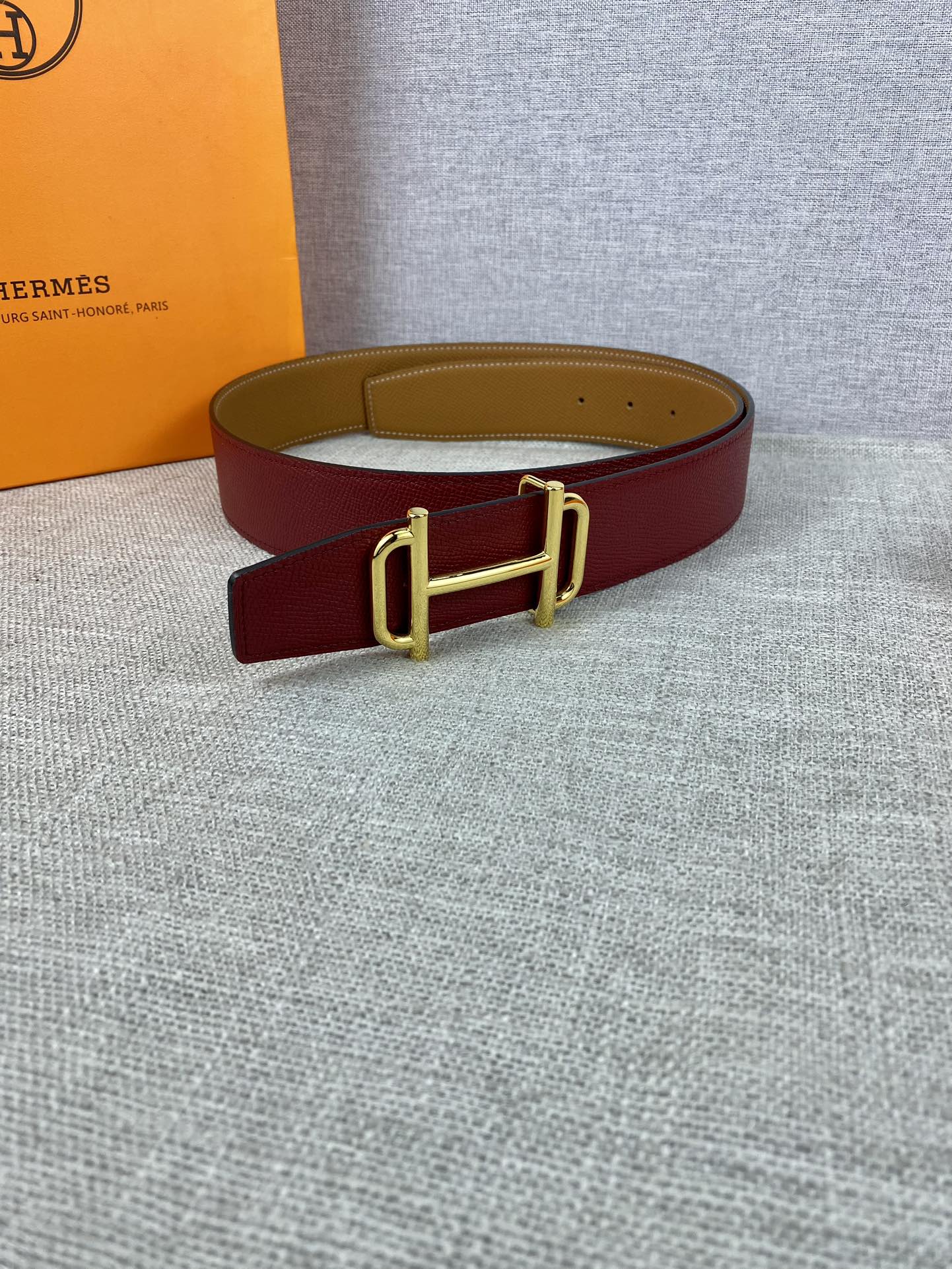 Burgundy leather belt with gold-tone buckle and keeper loop