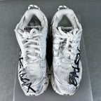 Unisex white sneakers with BALENCIAGA on heel, black graffiti-style side marks