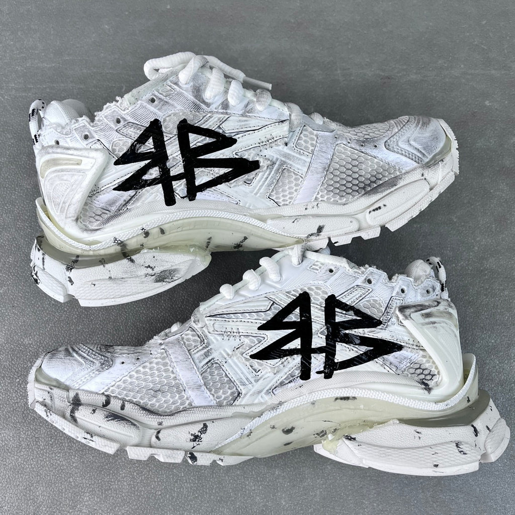 Unisex white sneakers with black graffiti-style print, lace-up, thick midsole
