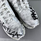 Unisex white sneaker with black graffiti-style print, textured upper, lace-up