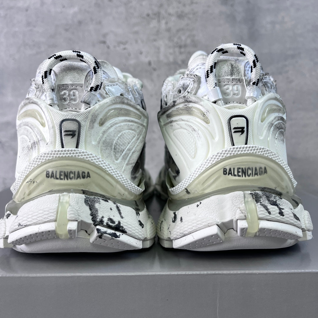 Unisex white sneakers showing heel branding and black graffiti-style side accents
