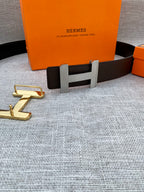 Hermes belt with dark leather strap and gold-tone H buckle