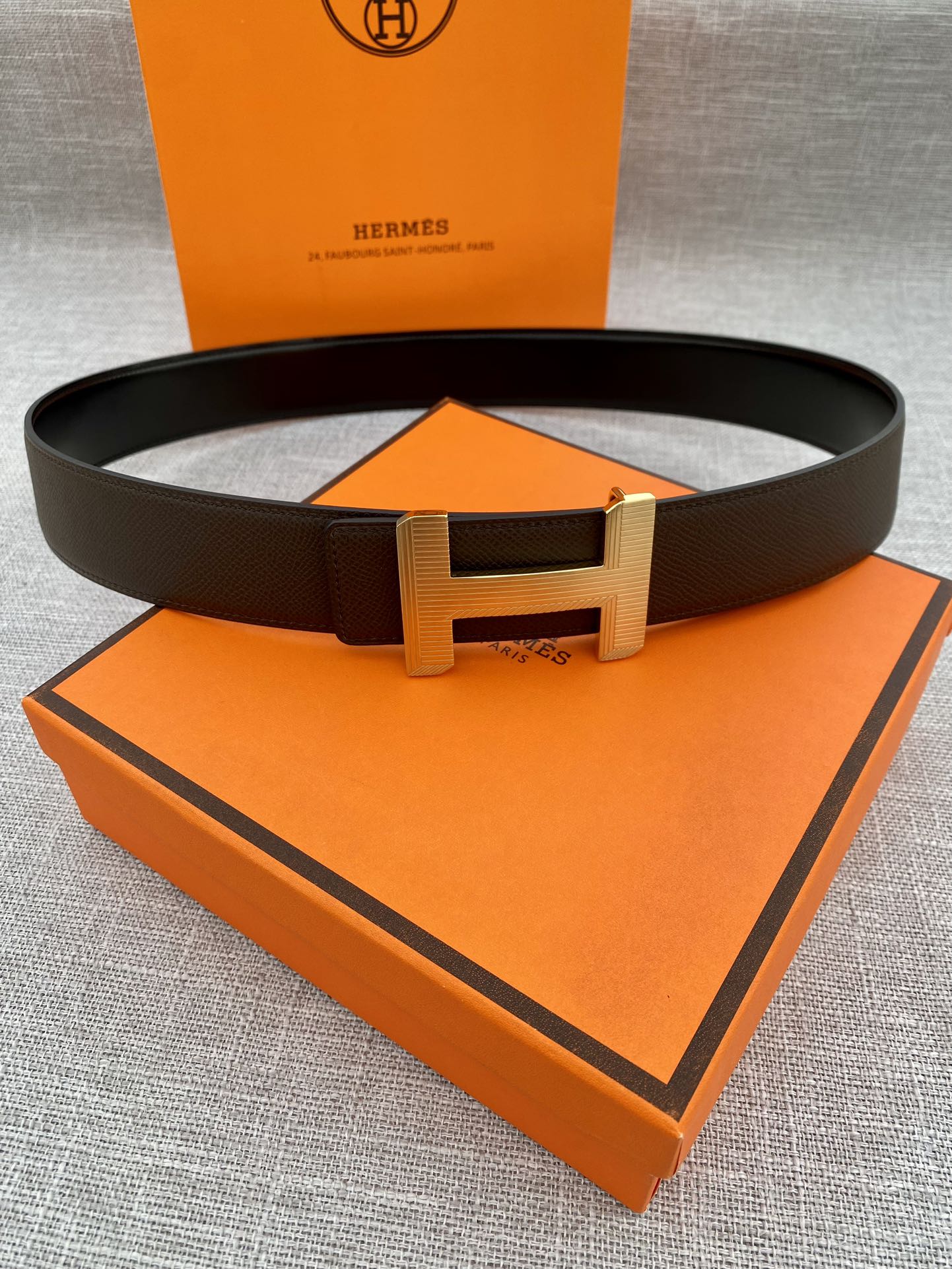 Hermes belt with dark leather strap and gold-tone H buckle
