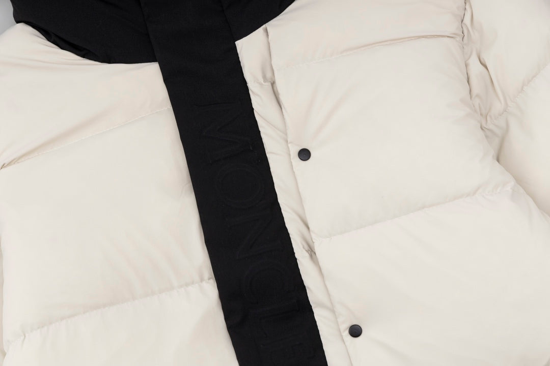 Cream puffer jacket front with black placket and visible snap buttons.