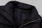 Black long puffer jacket close-up of side zipper and quilted fabric texture.