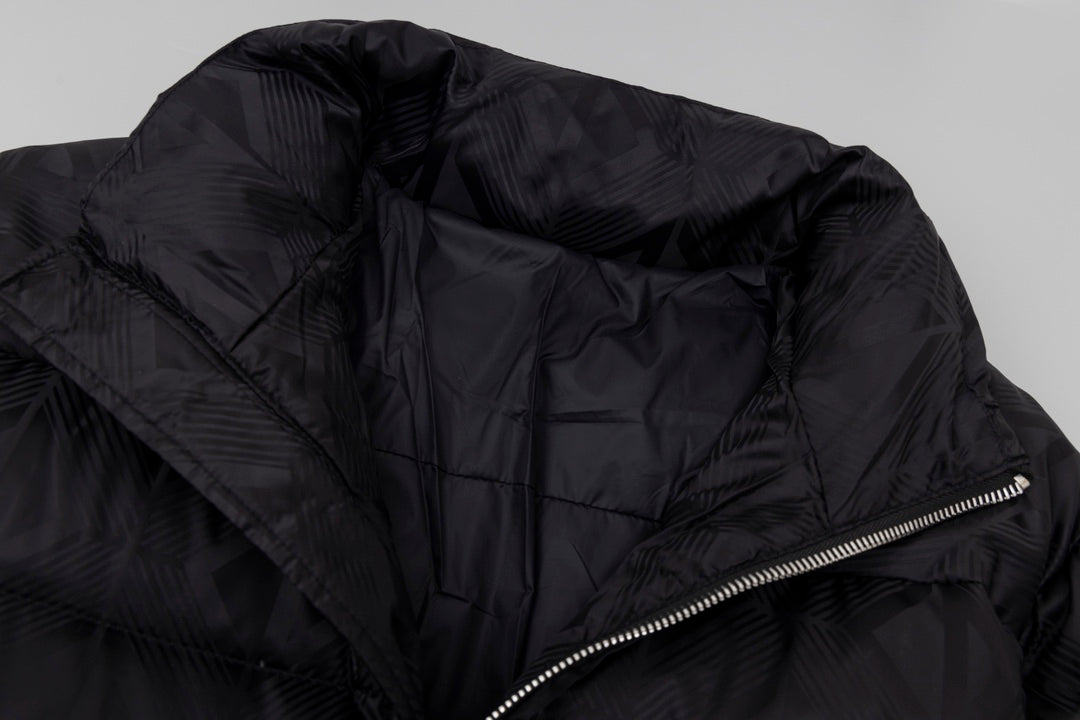 Black long puffer jacket close-up of side zipper and quilted fabric texture.