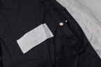 Black long puffer jacket shoulder detail with small button and Dior label.