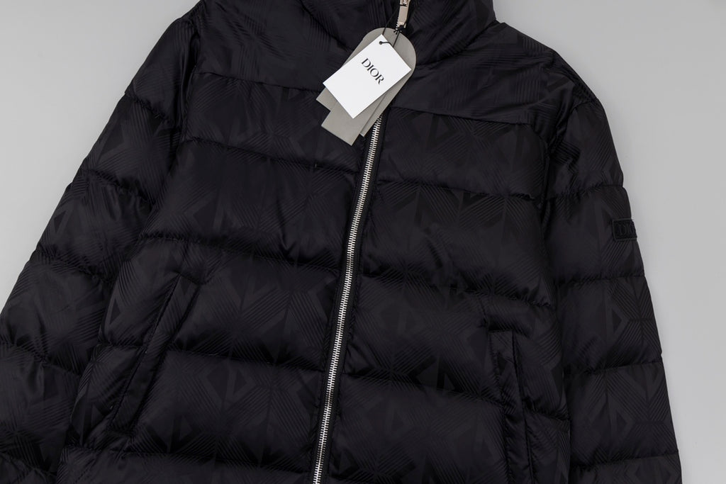 Black long puffer jacket close-up with front zipper and quilted panels.