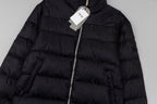 Black long puffer jacket close-up with front zipper and quilted panels.