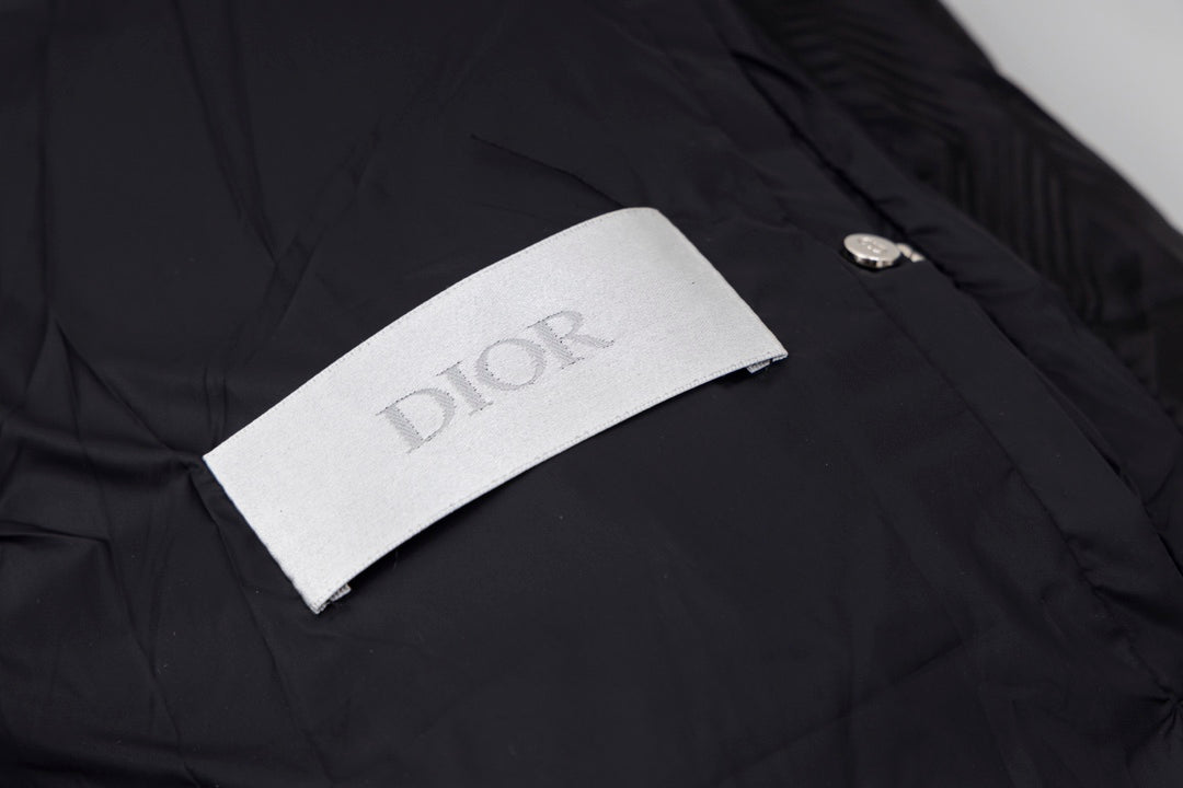 Black long puffer jacket with Dior logo fabric label on the chest.