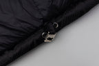 Black long puffer jacket cuff close-up with snap button and zipper hardware.