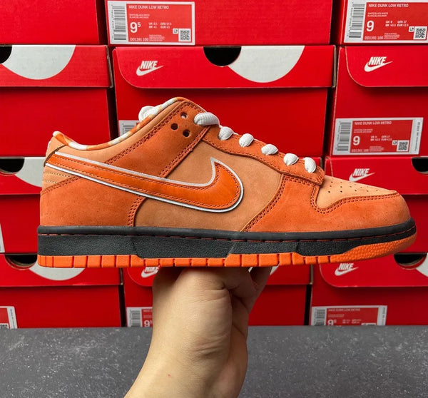 Orange suede SB Dunk Low sneaker with Nike Swoosh and white lace eyelets