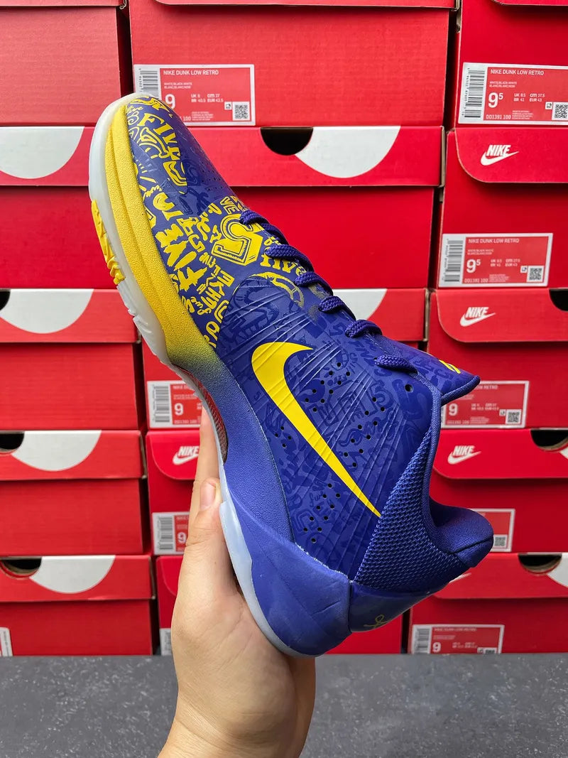 Blue basketball sneaker angled side view with yellow swoosh and graphic panels