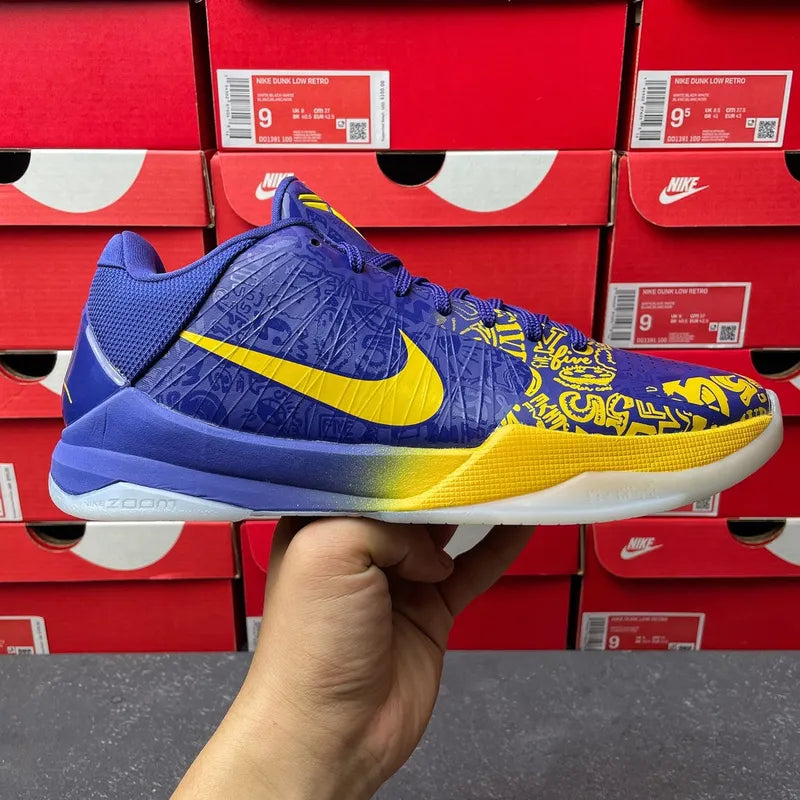 Blue basketball sneaker side view with yellow swoosh and gradient sole