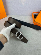 Dark leather belt with silver-tone double H buckle, strap and buckle detail.