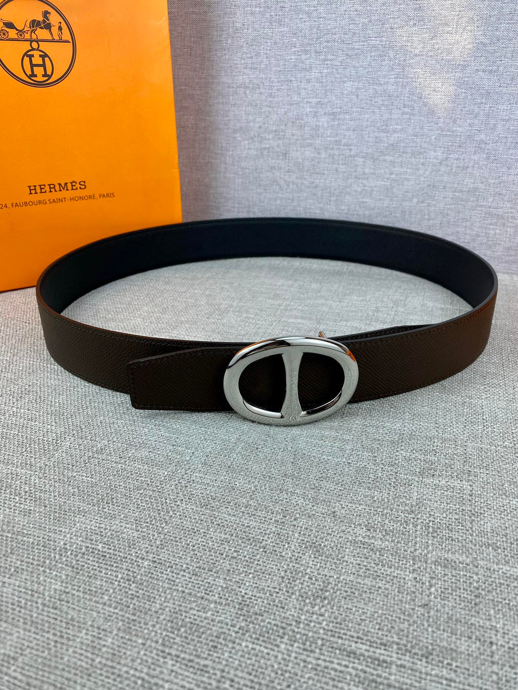 Dark leather belt with silver-tone double H buckle, full loop view.