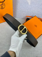 Dark leather belt with gold-tone double H buckle.