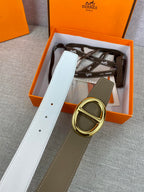 Gold double-ring buckle on olive leather belt with white backing strap