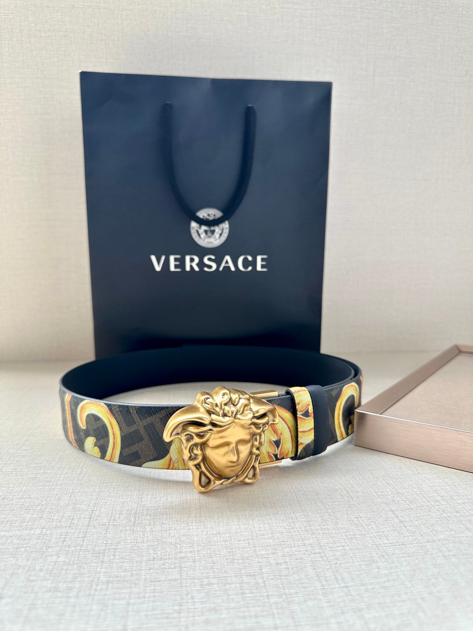 Versace dark blue belt with gold Medusa buckle and patterned baroque strap sections.