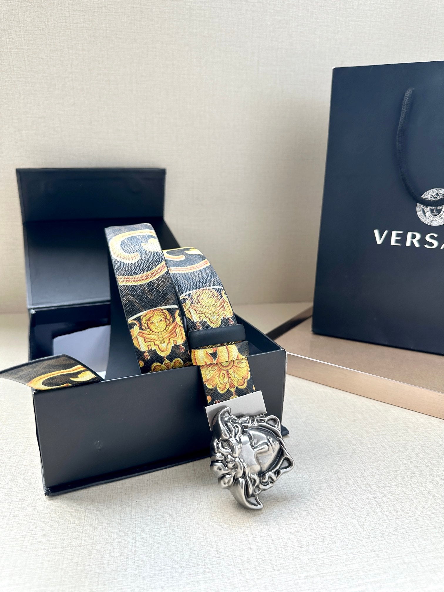Versace belt in box: baroque gold print belt with dark blue strap and Medusa buckle.