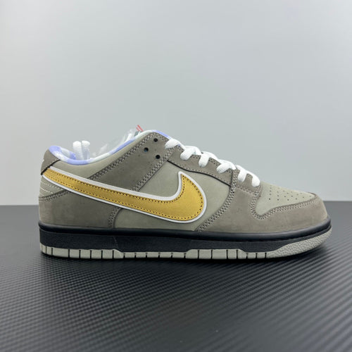 Grey suede low-top sneaker side view with yellow swoosh and white lace-up
