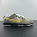 Grey suede low-top sneaker with yellow swoosh, white laces, black sole trim