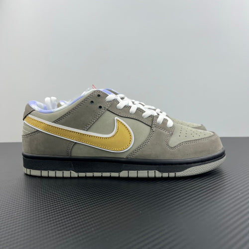 Grey suede low-top sneaker with yellow swoosh, white laces, black sole trim