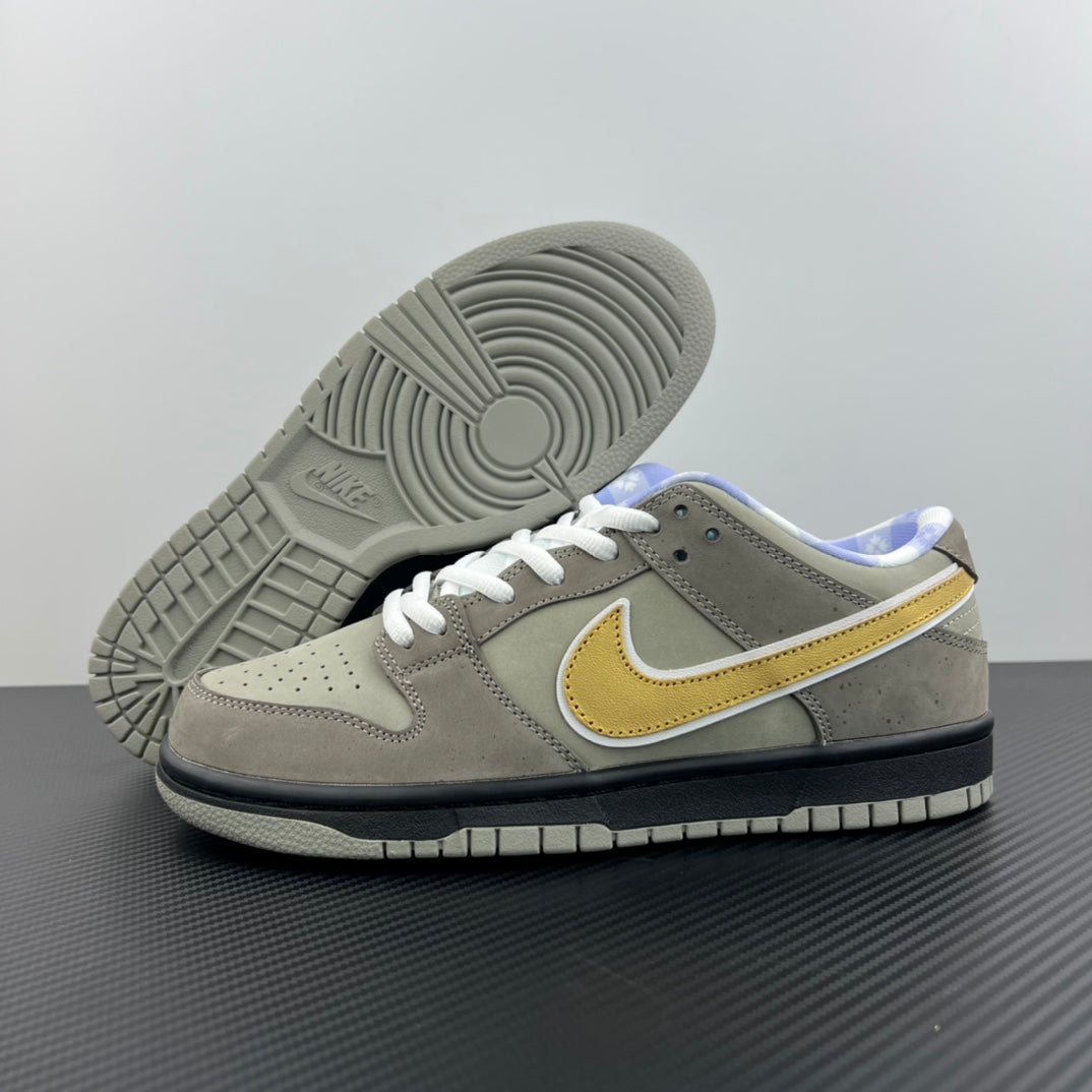 Grey suede low-top sneaker with white laces, yellow swoosh, textured outsole